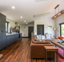 A living room with a sofa and coffee table at Y Cwt in Moelfre