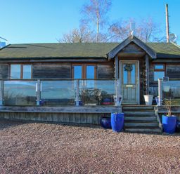 A wooden cabin with a glass railing and blue plant pots at Hillview in Stottesdon near Cleobury Mortimer