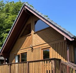 A wooden cabin with a deck and large windows at Number 39 Bodmin