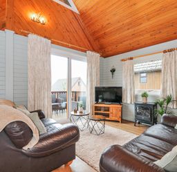 A living room with a sofa and coffee table at Cornish Woodland Retreat Near St Tudy