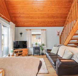 A living room with a sofa and television at Cornish Woodland Retreat Near St Tudy