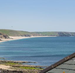 A coastal landscape with sandy beaches rocky cliffs and green hills by the sea at The Loft in Porthleven