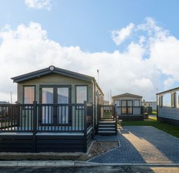 Two mobile homes with porches and paved driveways in an outdoor setting at The Sea Lodge in Bacton near Walcott