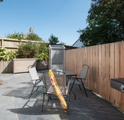 An outdoor area with a table and chairs at Pentire in St Minver