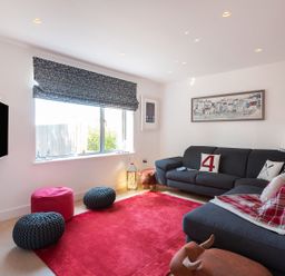 A living room with a sofa and television at Pentire in St Minver