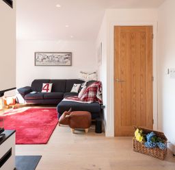 A living room with a sofa and a door at Pentire in St Minver