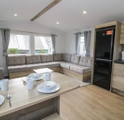 A living room with a sofa and dining table at Lido Silver Plus 111 Prestatyn