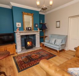 A living room with a fireplace and television at 9 Longhirst Village in Morpeth