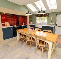 A kitchen with a wooden table and chairs at 9 Longhirst Village in Morpeth