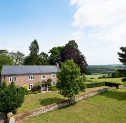An exterior view of a house with trees and a garden at Henhouse Farm in Bodenham