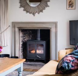 A living room with a stove and sofa at Henhouse Farm in Bodenham