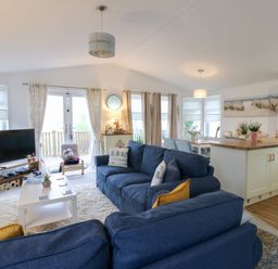 A living room with a sofa and television at The Sanctuary Badgers Retreat Holiday Park near Catterick Garrison, North Yorkshire