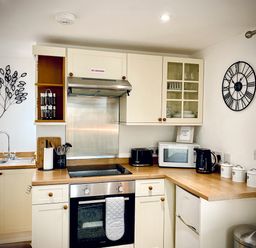 A kitchen with stove oven microwave toaster kettle and canisters at The Studio in Crackington Haven