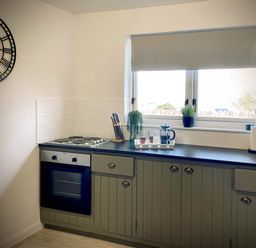 A kitchen with an oven stove countertop window knife block and plants at Penkenna in Crackington Haven