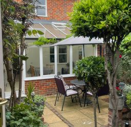 A garden with a table and chairs under an umbrella at Bay Tree Cottage, Peasenhall