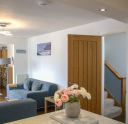 A living room with a sofa and bookshelf at Maceley in Kingsbridge