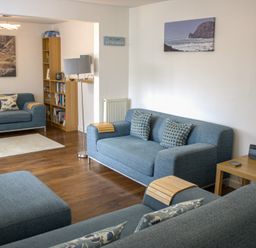 A living room with sofas and a bookshelf at Maceley in Kingsbridge