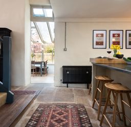 A kitchen with bar stools and a dining area at The Old Coach House Eglingham near Alnwick