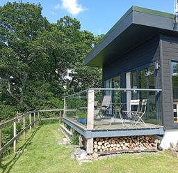 A deck with chairs and a table at Dundarach Aberfeldy