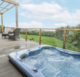 An outdoor space with a hot tub and seating area at Petroc in Portreath
