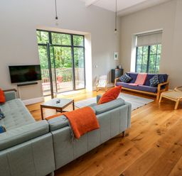 A living room with sofas and a television at The Old Creamery in Ffairfach