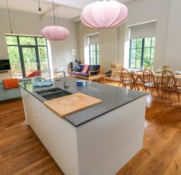 A kitchen with a dining area and a sofa at The Old Creamery in Ffairfach