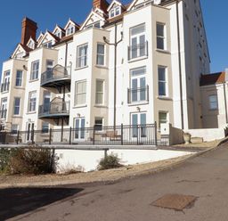 An exterior view of a multi-story residential building with balconies and windows at Apartment 7 Mansion House Tenby