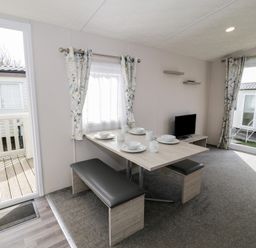 A dining area with a table and chairs at Gold Caravan (316) Talybont
