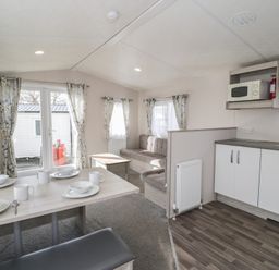 A living room with a sofa and dining table at Gold Caravan (316) Talybont