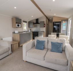 A living room with sofa and kitchen area at Gold Caravan (203) Talybont