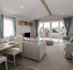 A living room with a dining area and sofa at Gold Caravan (203) Talybont