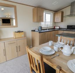 A dining area with a table set in Gold Lodge (201) Talybont