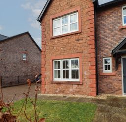 The exterior of a brick house with white framed windows a dark front door and a small front garden at 4 Centurion Rise Penrith
