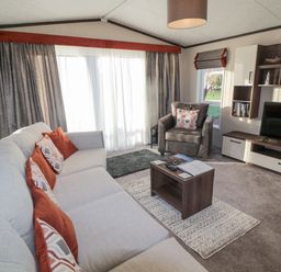 A living room with a sofa and armchair a coffee table and a television at Downtime Lodge near Felton
