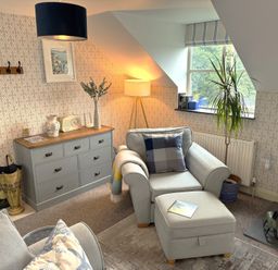 A living room with an armchair and chest of drawers at The Hayloft in Lostwithiel