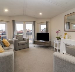 A living room with sofas a television on a stand and windows with curtains at Longdon Lodge in Wickhamford near Evesham