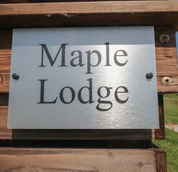 A sign displaying Maple Lodge located in Whitby