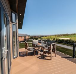 An outdoor seating area with a table and chairs at Holly Lodge in Whitby