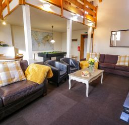 A lounge area with sofas chairs a coffee table a pool table and a dining table at Igamogam Llanllyfni near Penygroes
