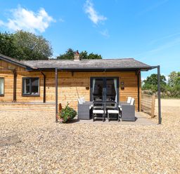 An outdoor patio area with a dining table and chairs at Rabbit Warren Lodge in Snettisham