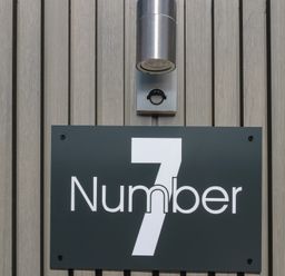 A house number sign with a light fixture at Number 7 in Bishop Sutton