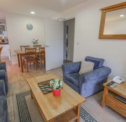A living room with armchairs a coffee table and a dining table in the background at Pierpont D1 Norton near Yarmouth