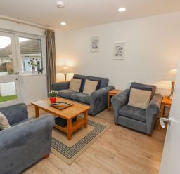 A living room with gray sofas a wooden coffee table and lamps at Pierpont D1 in Norton near Yarmouth