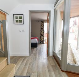 A hallway with stairs and a doorway leading to a bedroom at Coastguard Lookout in Wyke Regis