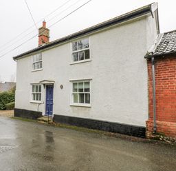A house exterior view with a blue door at White Gates in Banham