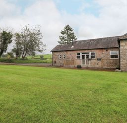 An outdoor view of a stone building with a wooden deck at The Gatehouse 