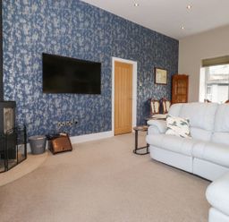 A living room with a sofa and television at The Gatehouse 