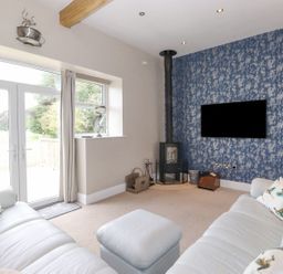 A living room with a sofa and a television at The Gatehouse in 