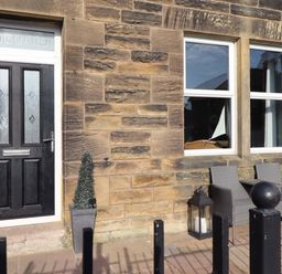 A front entrance with a door and seating area at Dinguardi in Seahouses