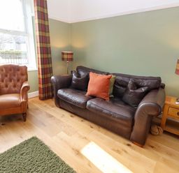 A living room with a sofa and chair at Dinguardi in Seahouses